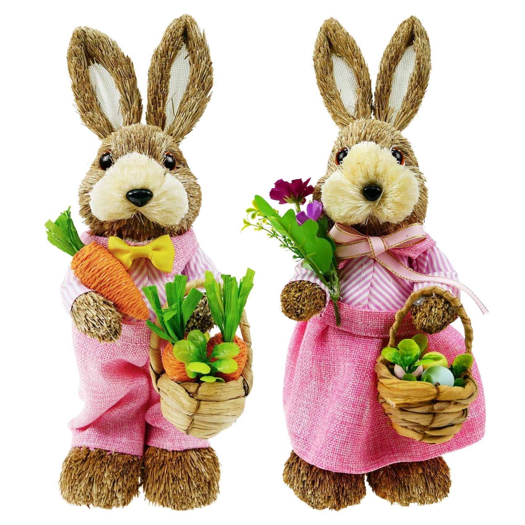 Two sisal bunny figurines in pink outfits, one holding carrots and a basket of carrots, the other holding flowers and a basket of Easter eggs.