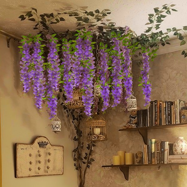 Purple artificial wisteria flower vines hanging from a ceiling with decorative bird cages and a bookshelf in the background.