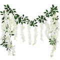Two white artificial wisteria flower garlands with green leaves against a white background.