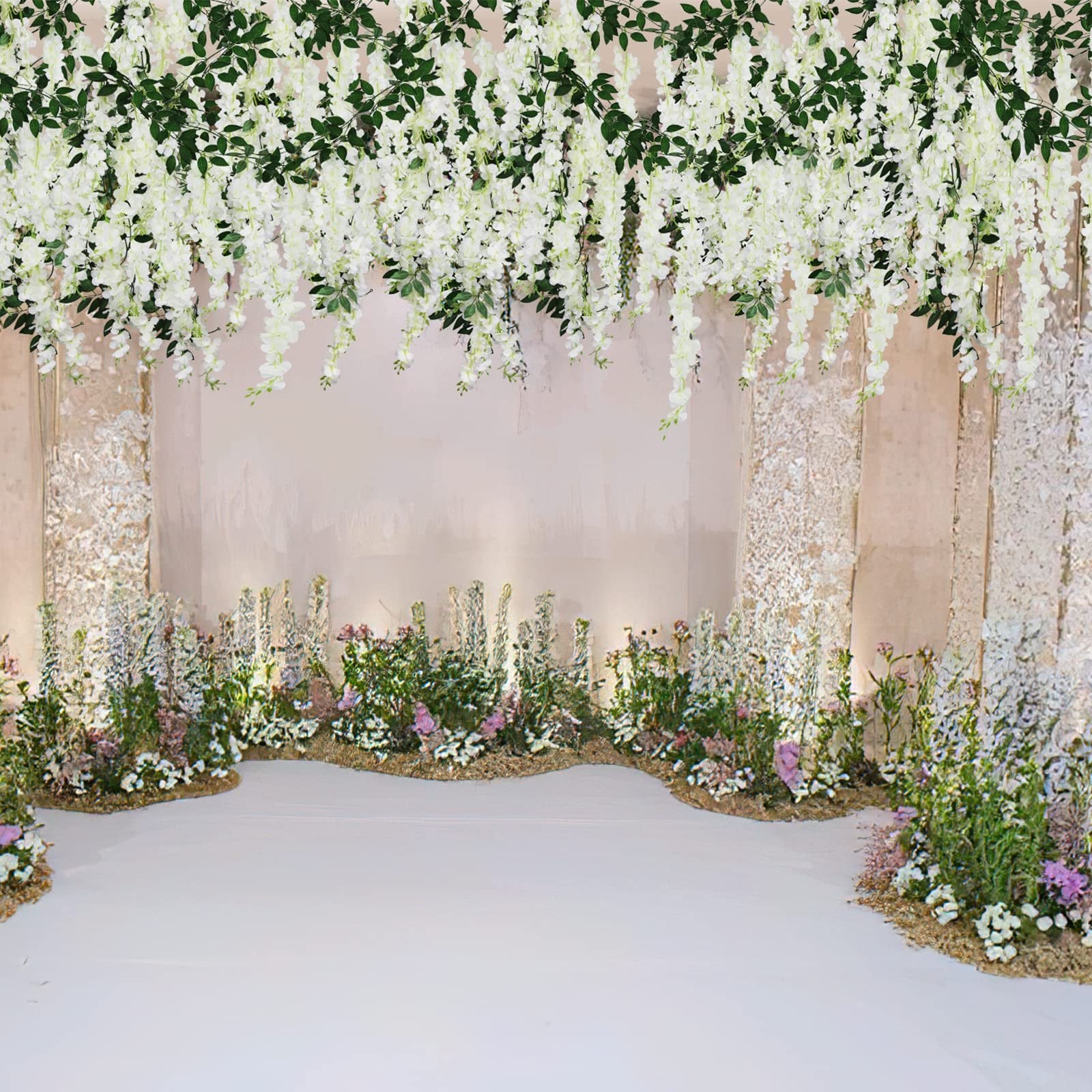 White artificial wisteria flower vines with green leaves draped over a floral arrangement and a white floor.