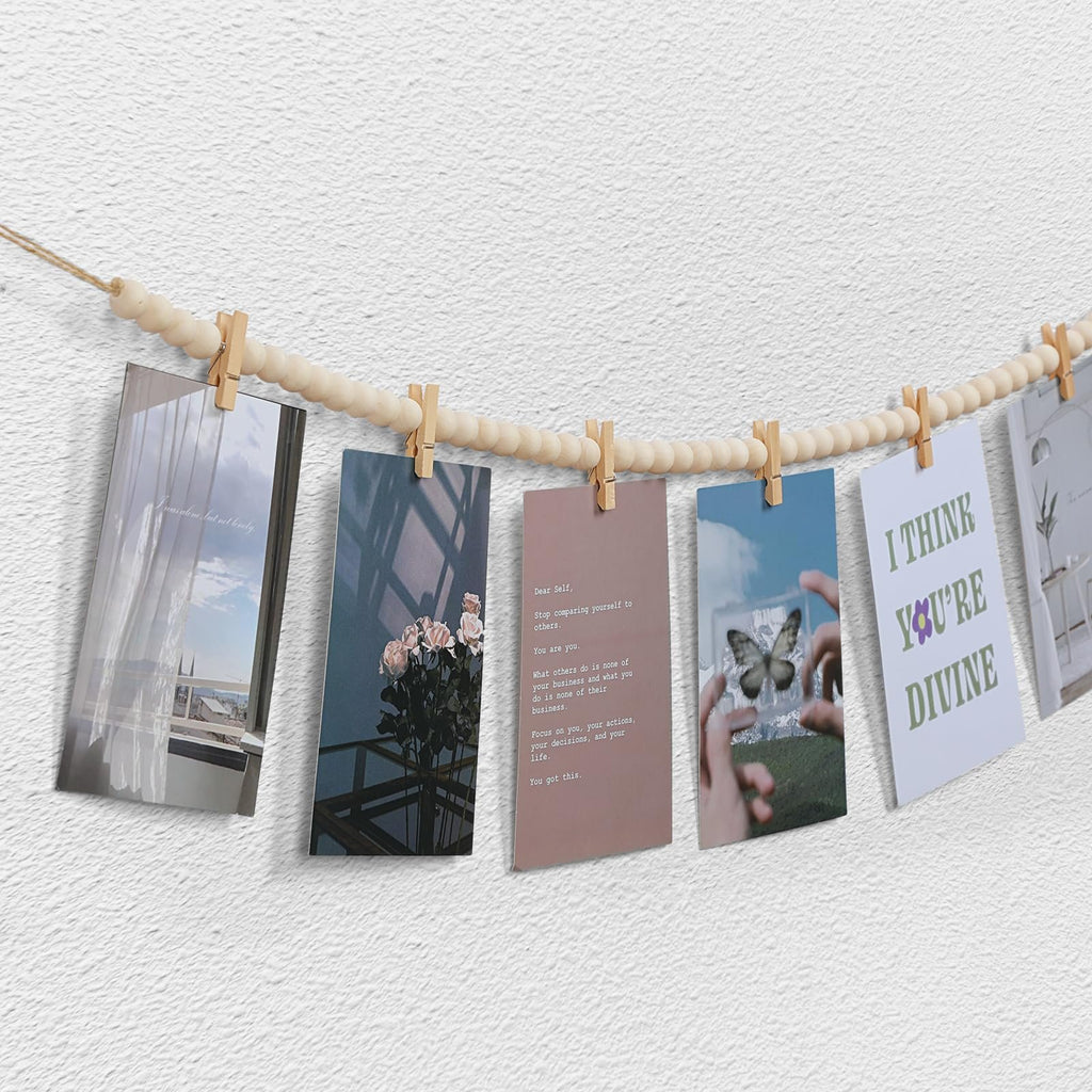 Boho wooden bead garland photo display with 10 clips holding various inspirational cards and photos against a textured wall.