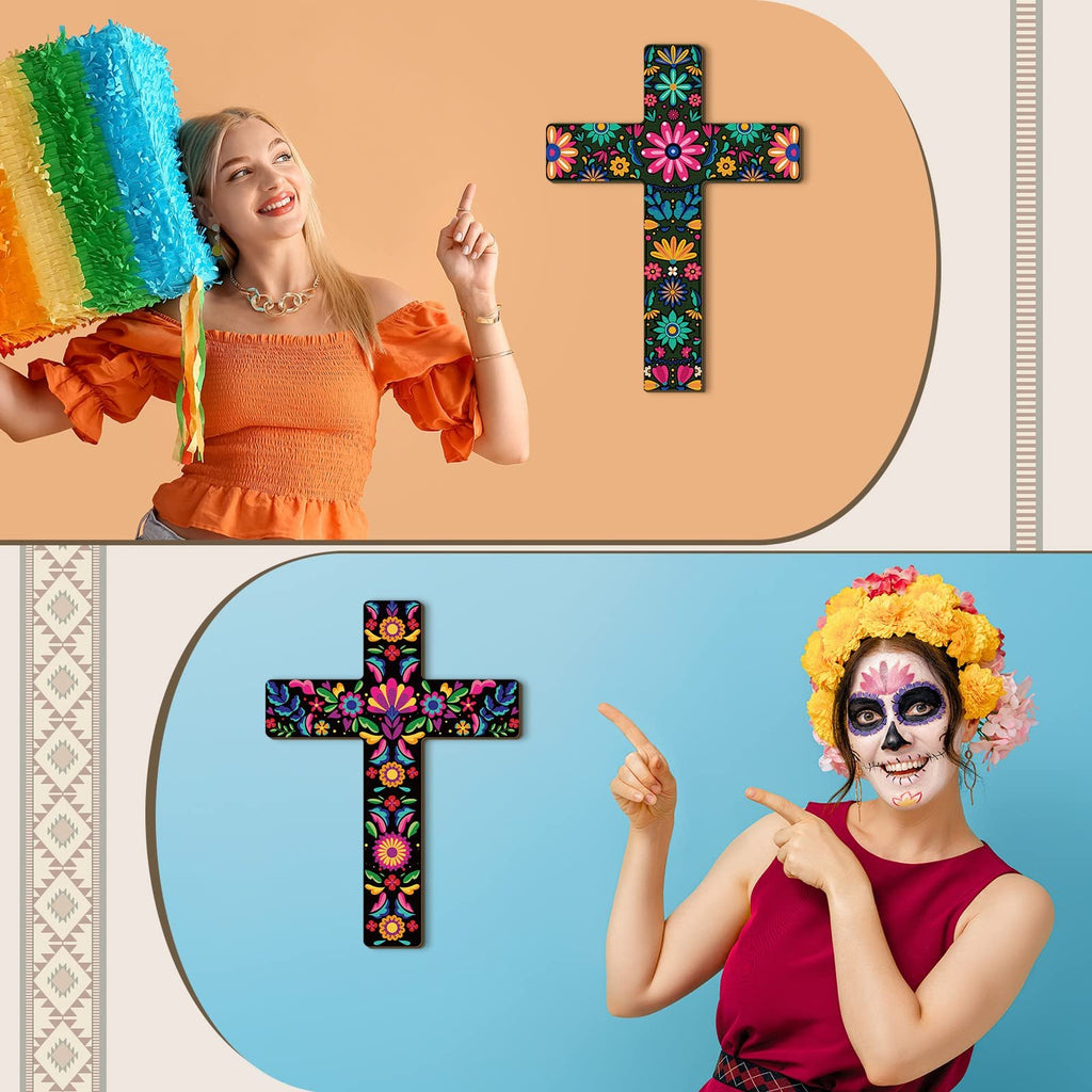 Woman holding a rainbow piñata points to a floral cross decor; woman with Day of the Dead makeup points to a floral cross decor