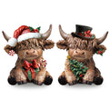 Two resin highland cow figurines dressed for Christmas, one with a Santa hat and gift, the other with a top hat and Christmas tree.