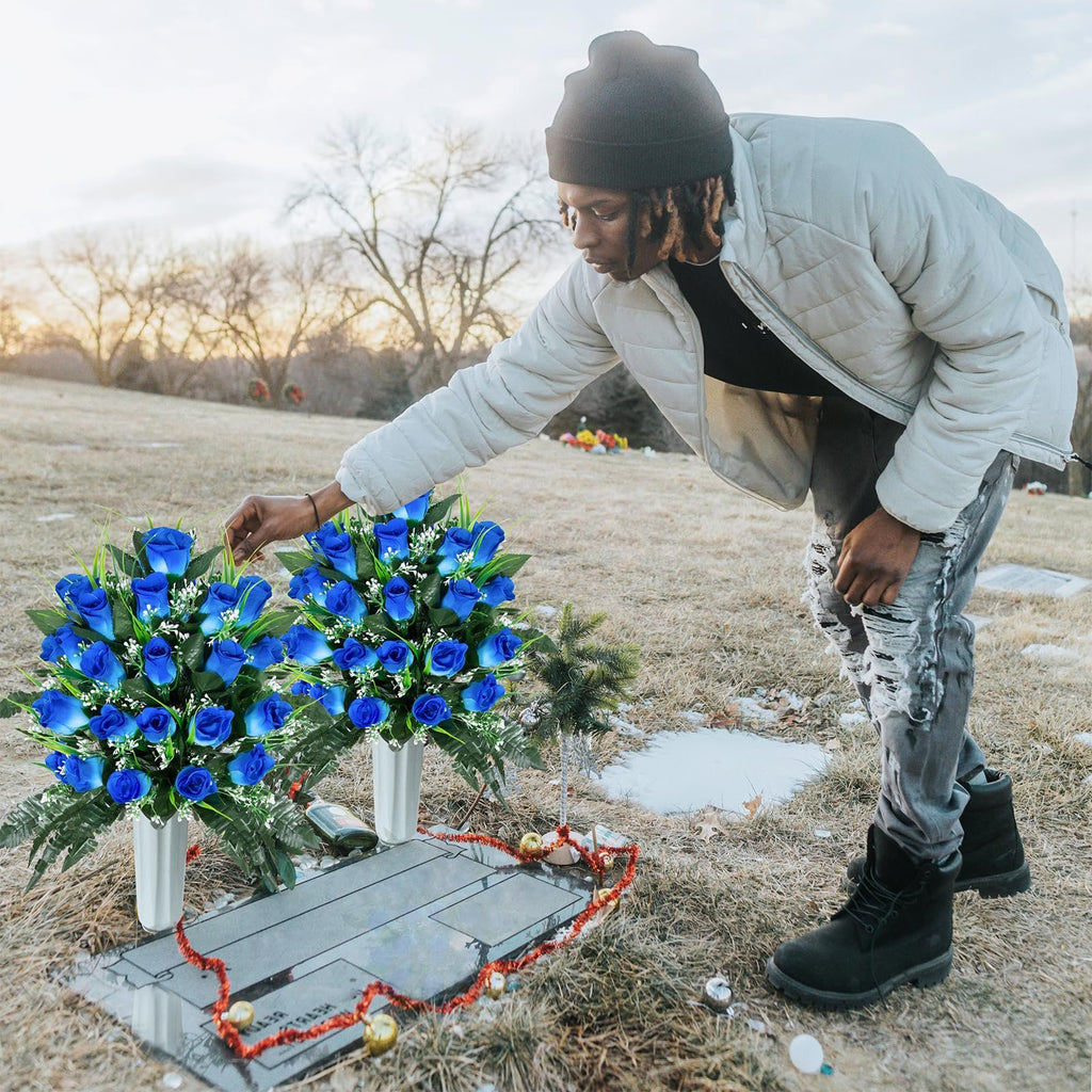 Person placing blue artificial rose bouquets in vases at a cemetery gravesite