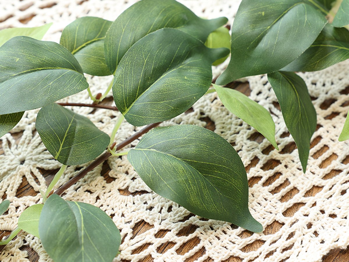 Close-up of artificial green leaves on a decorative lace doily