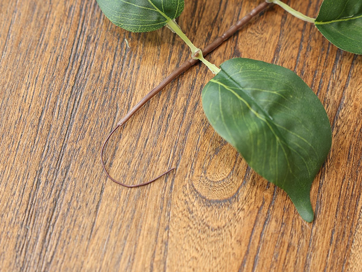 Close-up of artificial green scindaps vine leaves on a wooden surface
