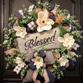Magnolia wreath with buffalo plaid bow and 'Blessed' wooden plaque, decorated with greenery and ribbons.