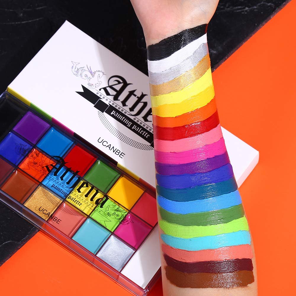 Arm with swatches of 20 colors from a face and body paint palette, with the palette open in the foreground.