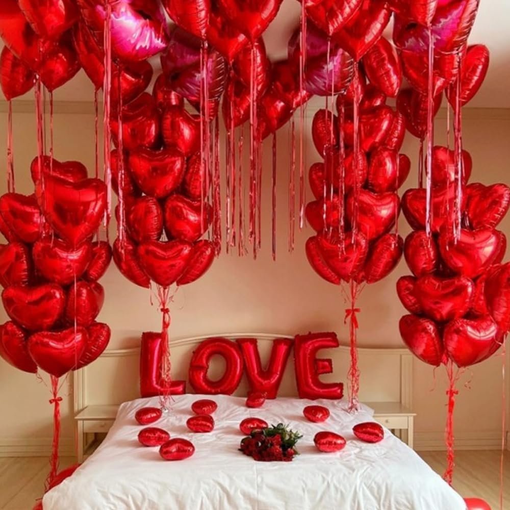 Red heart foil balloons and LOVE letter balloons decorating a bed for a romantic occasion