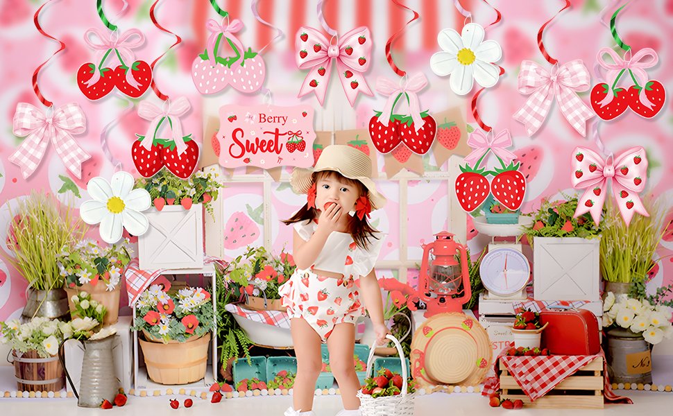 Child in strawberry-themed outfit eating fruit in a party scene with hanging strawberry and bow decorations.