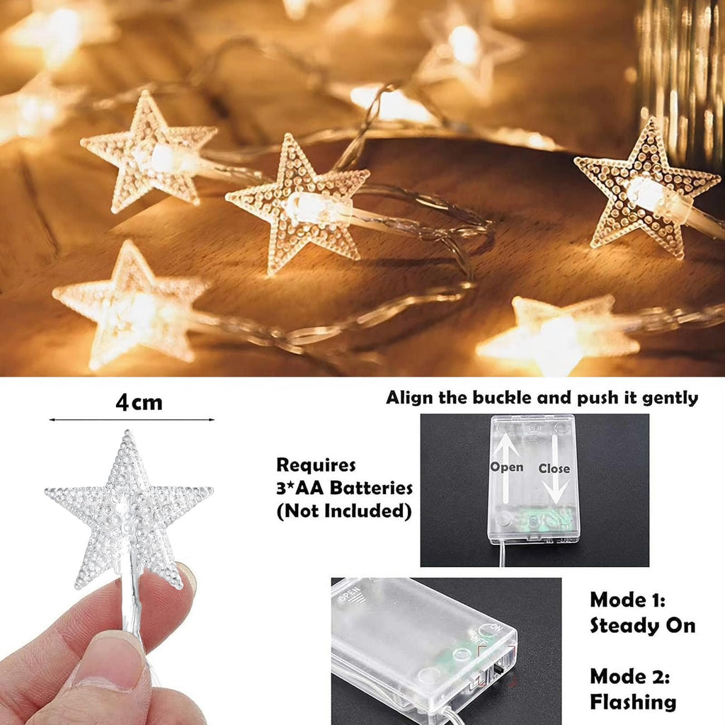 Close-up of warm white star-shaped string lights with a hand holding one star, showing size and battery pack details.