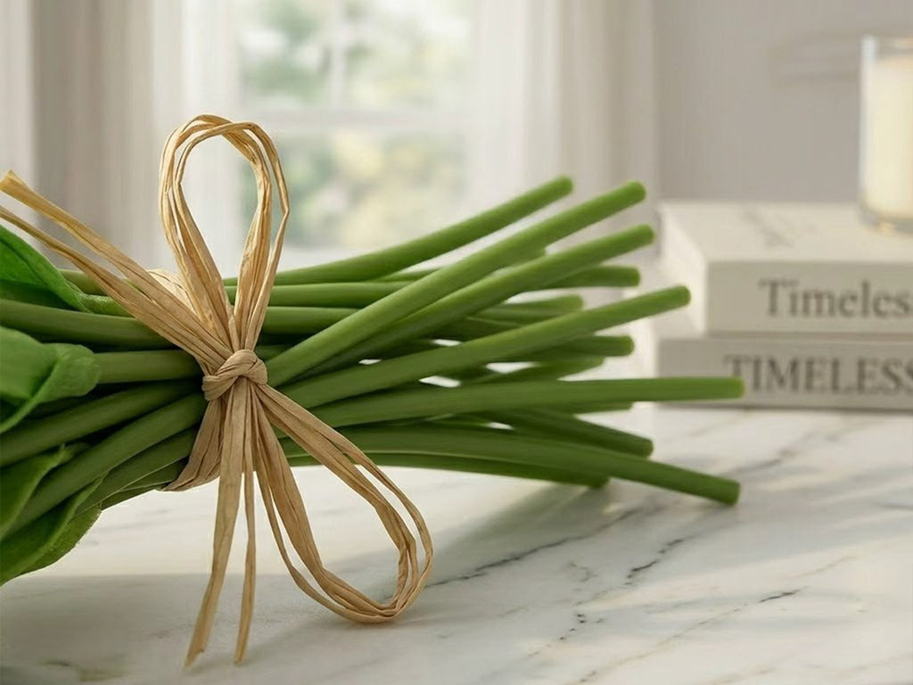 Bundle of 20 artificial tulip stems with green stalks tied with raffia, on a marble surface.
