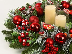 Close-up of a 20-inch Christmas wreath decorated with red ornaments, pine cones, berries, and candles.