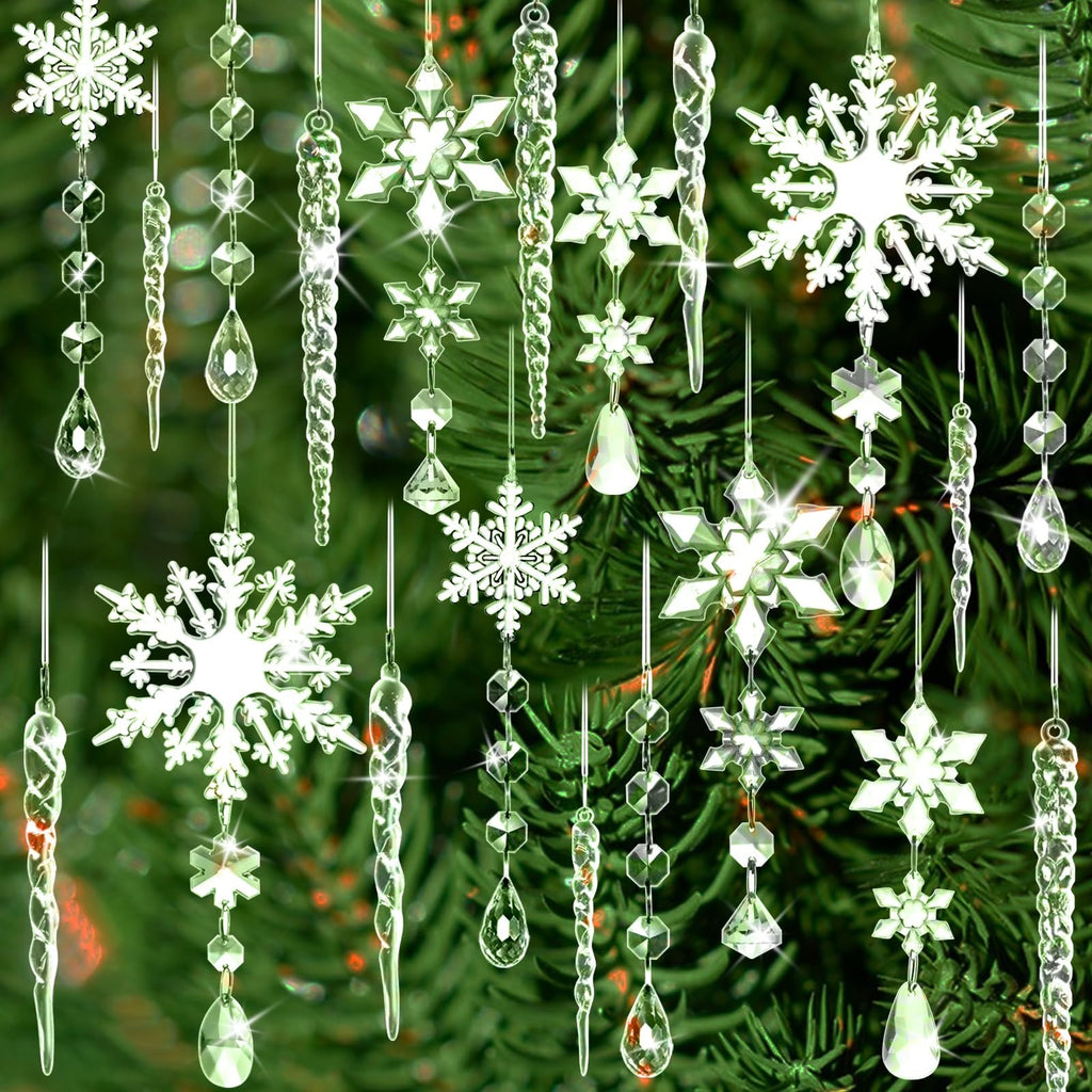 Assortment of clear acrylic snowflake, icicle, and drop ornaments hanging against a blurred green Christmas tree background.