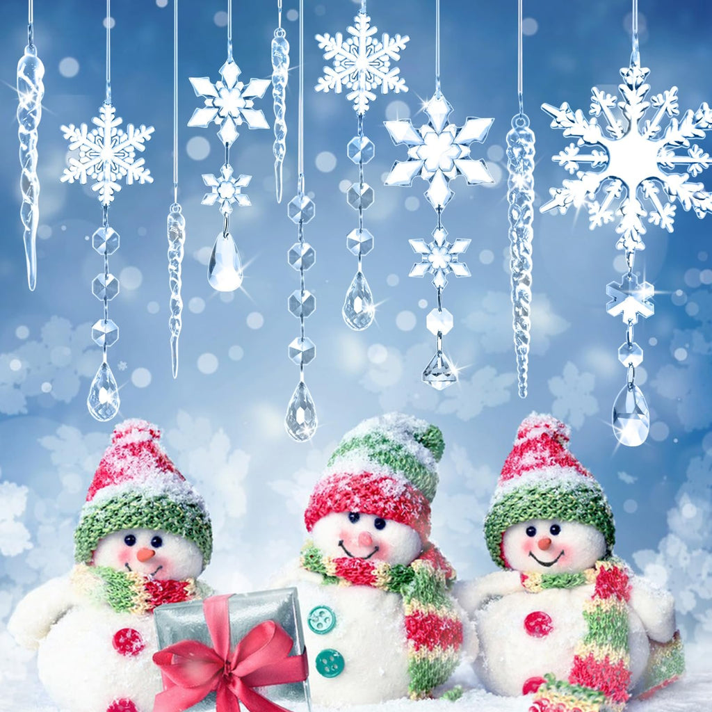 Three snowmen wearing hats and scarves stand in the snow, with hanging acrylic snowflake and icicle ornaments above them.