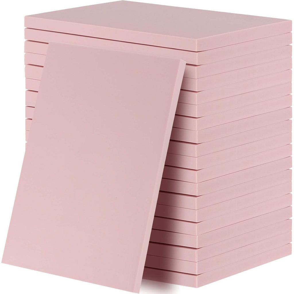 Stack of 20 pink rubber carving blocks for stamp making, one block leaning against the stack.