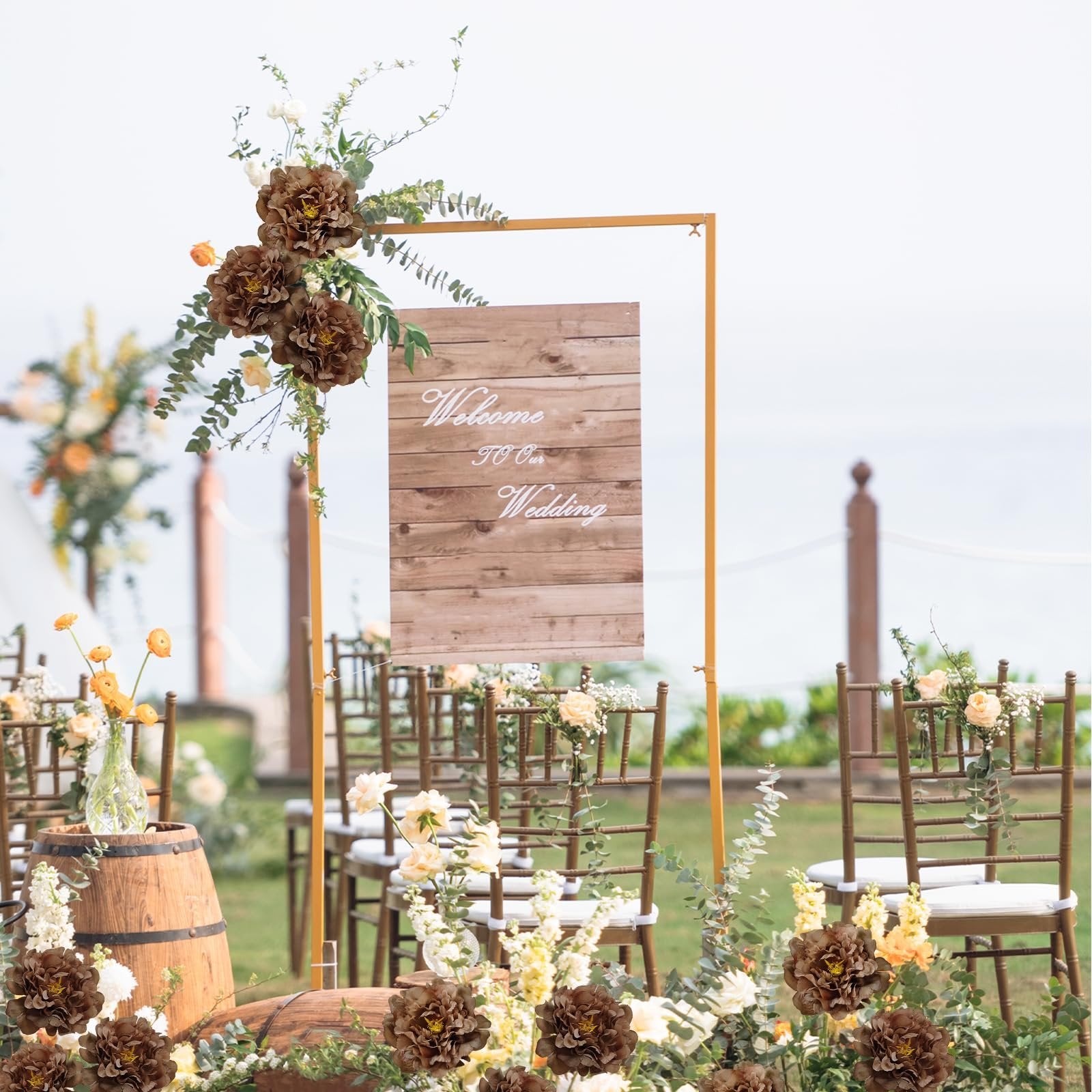 Wedding ceremony setup with artificial coffee-colored peony flowers and a wooden sign that says 'Welcome to Our Wedding'.