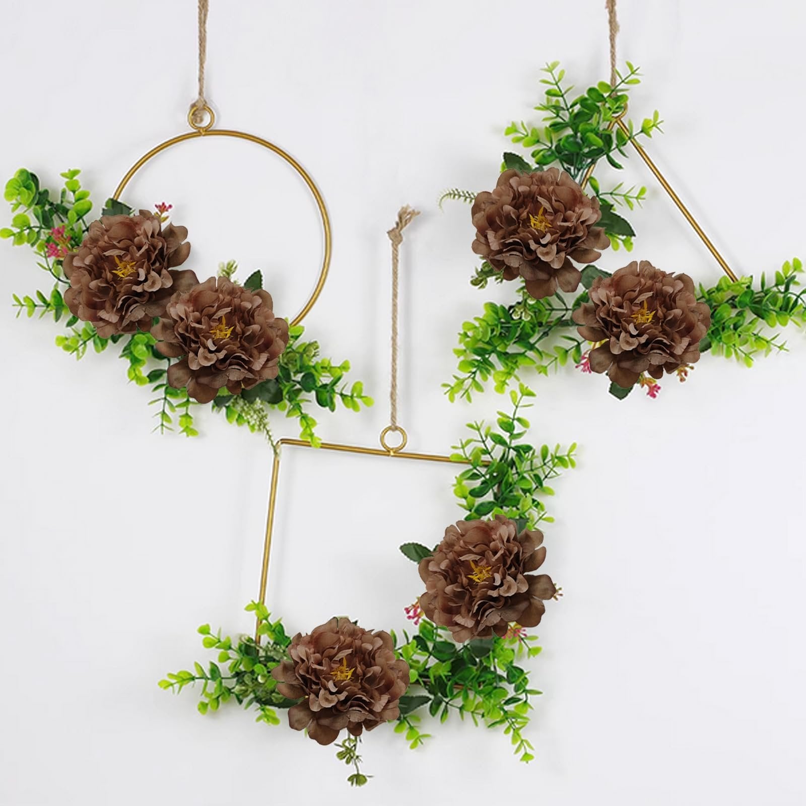 Three gold geometric frames decorated with brown artificial peonies and green foliage, hanging against a white background.