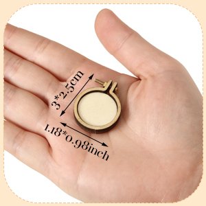 Hand holding a mini wood embroidery hoop with dimensions labeled in inches and centimeters.