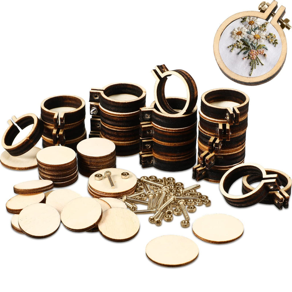 Mini wooden embroidery hoops and round wooden discs scattered on a white background, with one hoop showing a floral embroidery.