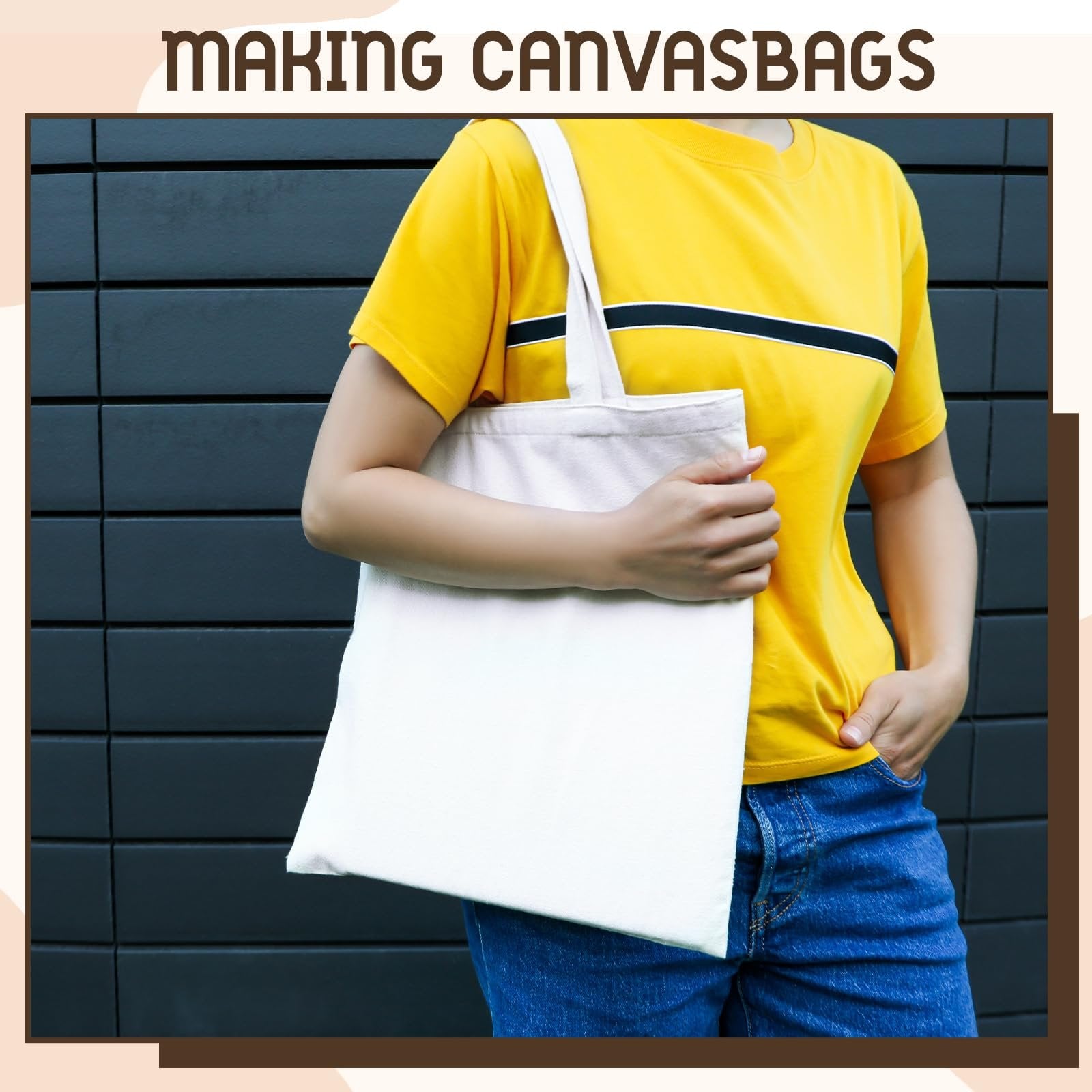 Person holding a white canvas tote bag in front of a dark wall