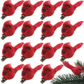 Grid of 19 red cardinal clip-on ornaments with metal clips, one ornament on a pine branch in the lower right corner.