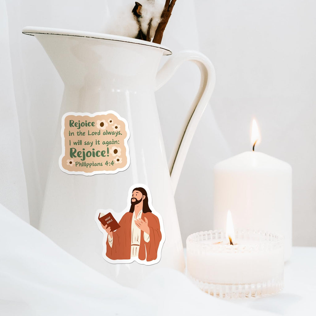 Christian stickers with Bible verse and Jesus illustration on a white pitcher near candles.