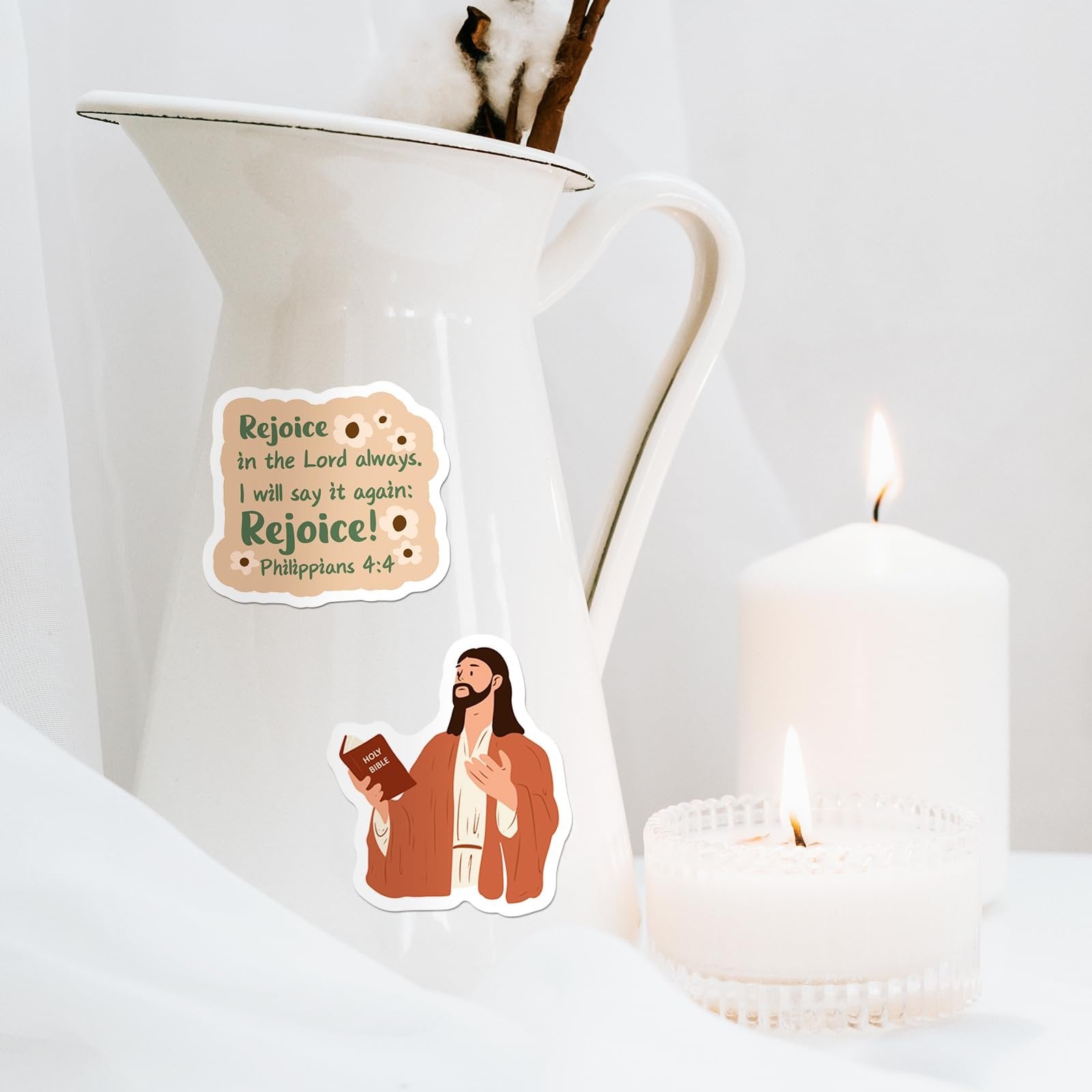 Christian stickers with Bible verse and Jesus illustration on a white pitcher near candles.