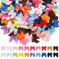 Collection of small, multicolored satin ribbon bows scattered and arranged in rows on a white background.