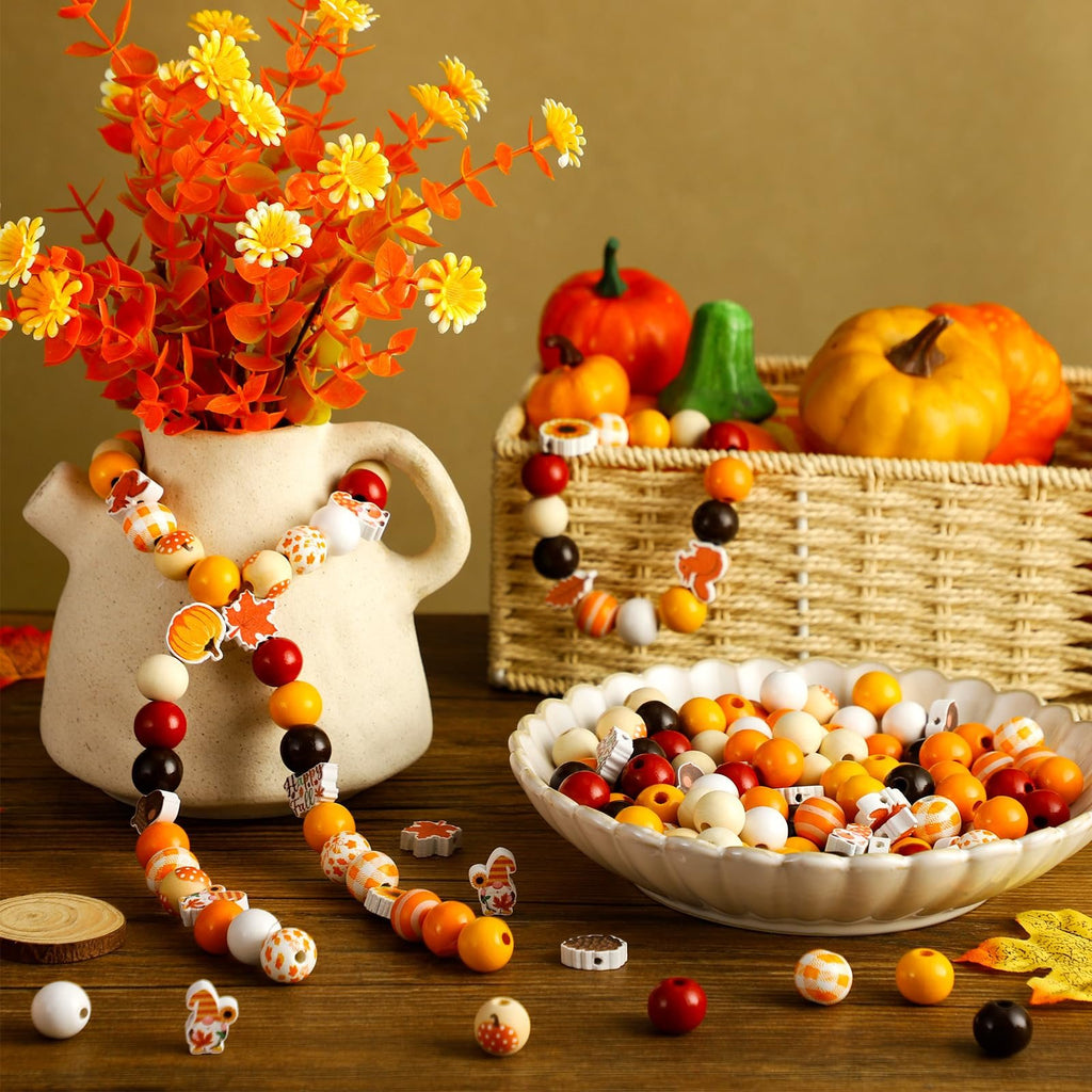 Thanksgiving wooden beads with maple leaves, pumpkins, and plaid patterns arranged in a bowl and on a vase.