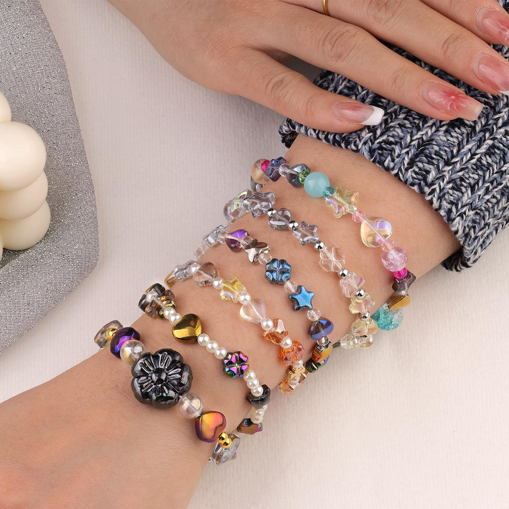 Close-up of a person's wrist adorned with multiple colorful beaded bracelets, showcasing various bead shapes and iridescent finishes.