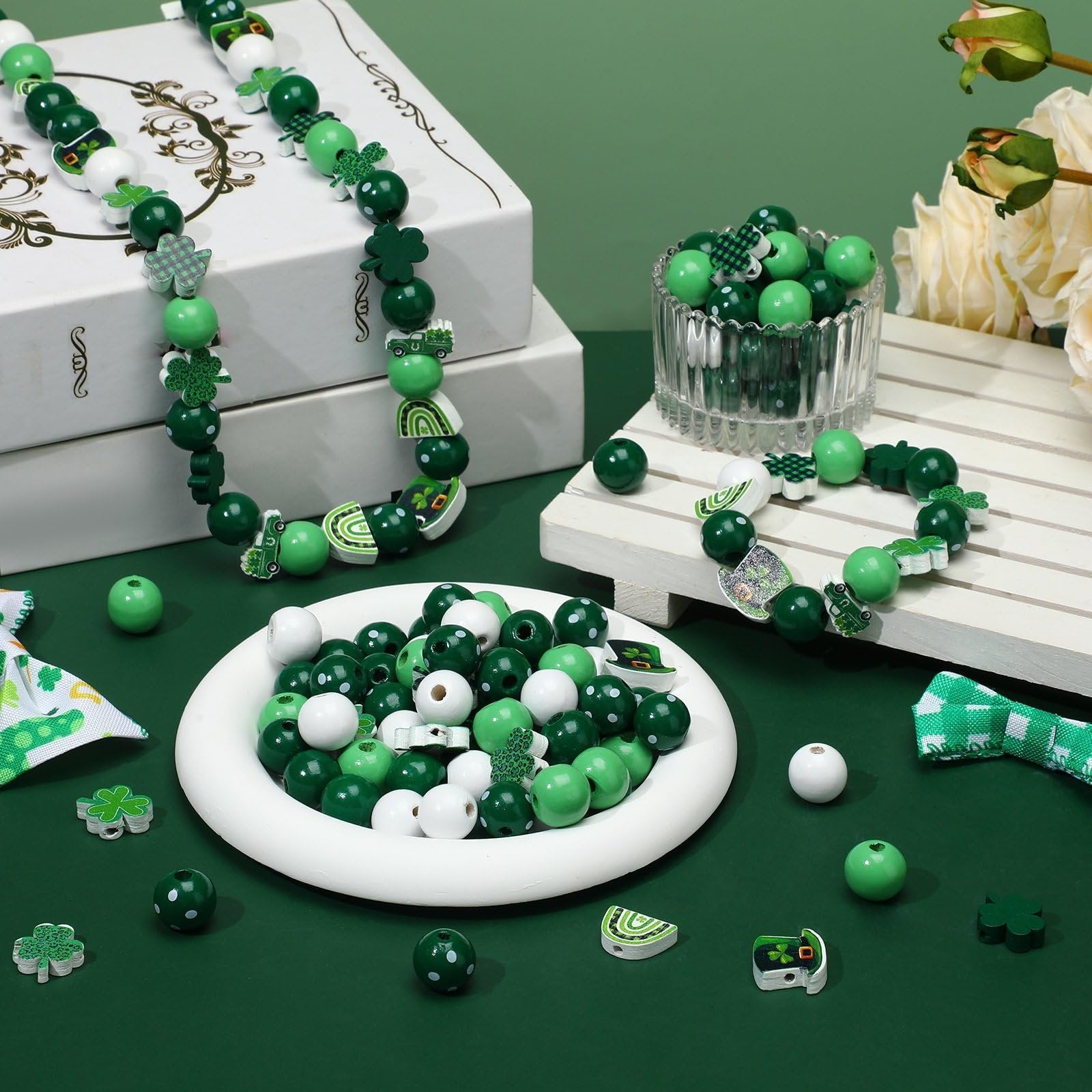 St. Patrick's Day themed wooden beads in green, white, and patterned designs, arranged on a plate and in a bowl, with finished necklaces and bracelets.