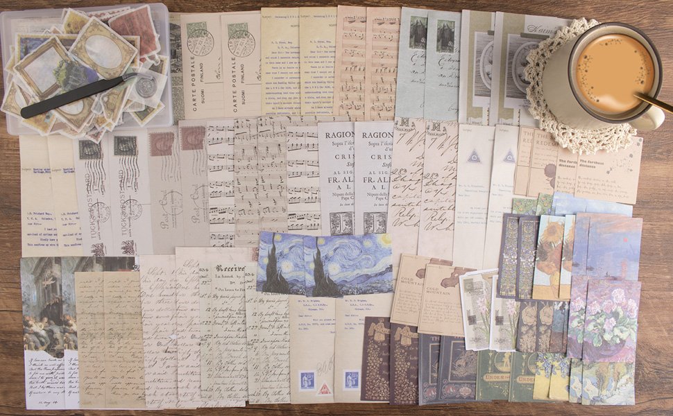 Flat lay of vintage scrapbook stickers, ephemera, and stationery with a cup of coffee on a wooden table.