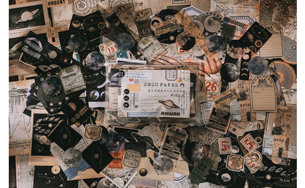 Scrapbooking kit with vintage planet and space-themed stickers and papers scattered.