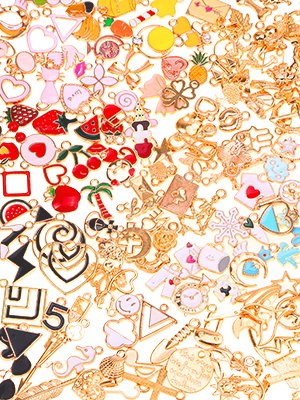 Assortment of colorful and gold-tone jewelry charms including fruits, hearts, animals, and geometric shapes.