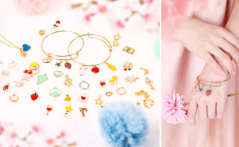 Assortment of colorful enamel and gold-tone jewelry charms scattered around two bracelets, with a hand wearing one bracelet on the right.
