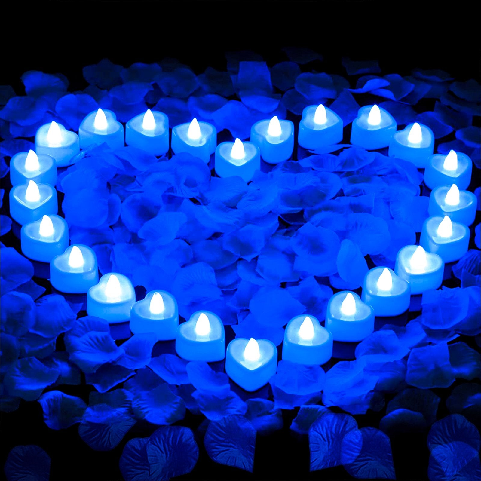 Heart-shaped LED tea lights arranged on blue rose petals, forming a larger heart shape.