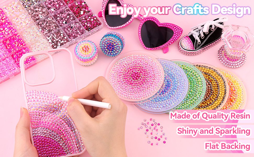Pink resin rhinestones and craft supplies arranged on a pink surface, with a hand decorating a phone case.