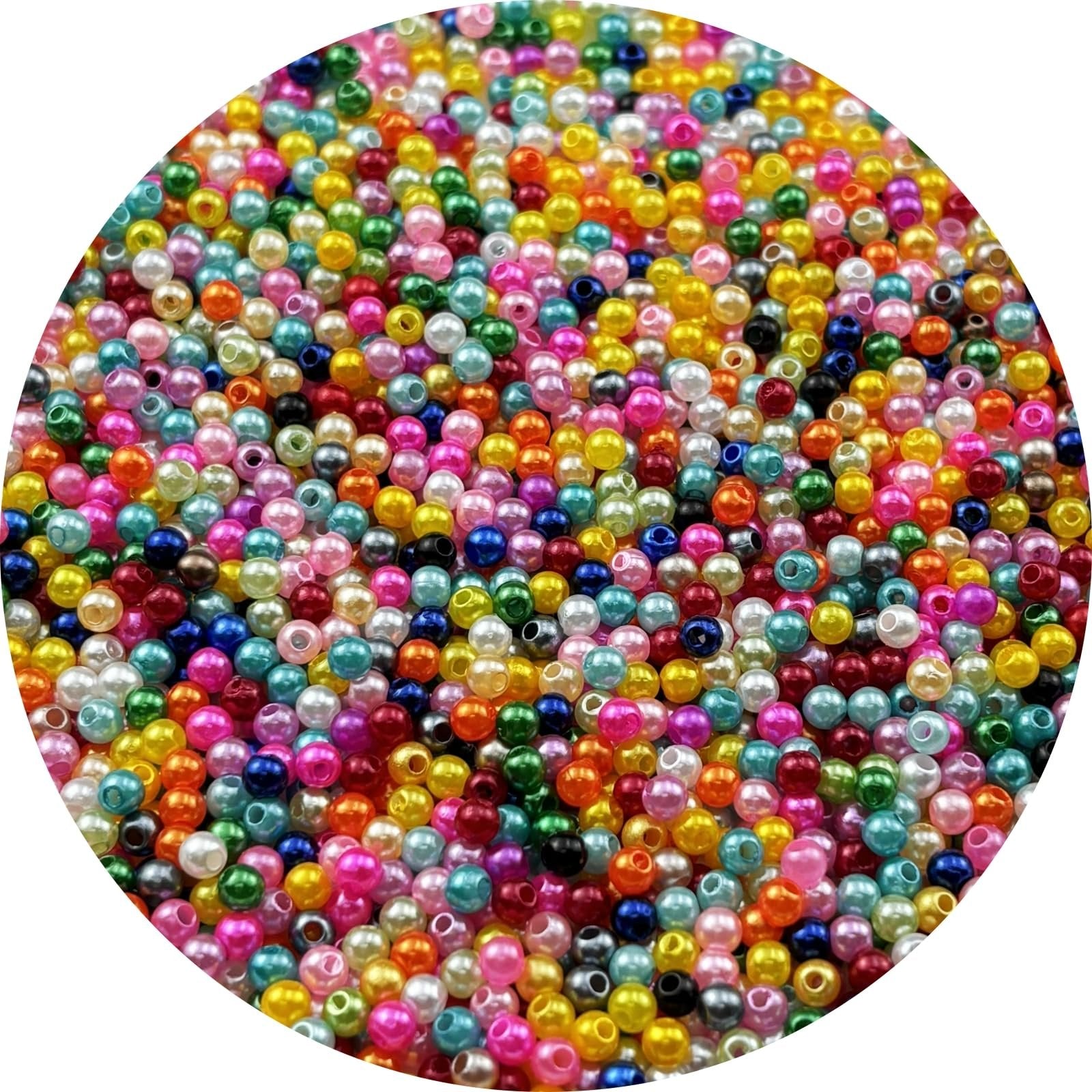 Close-up overhead view of a large pile of mixed color 4mm resin pearl beads with holes for jewelry making.
