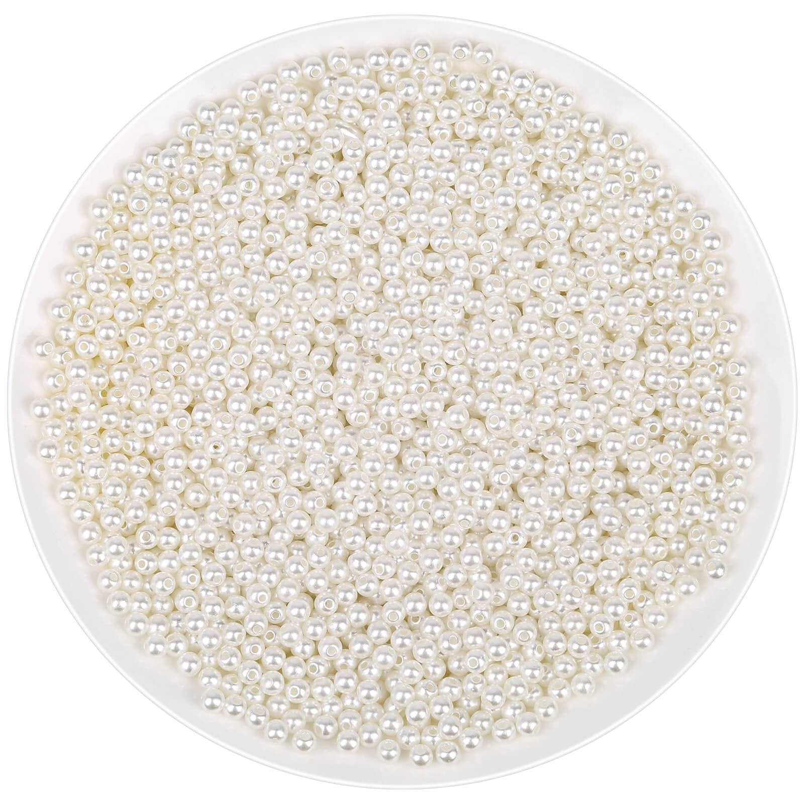 Ivory acrylic pearl beads with holes for jewelry making, shown in a white bowl.