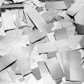 Pile of silver foil confetti pieces scattered across a surface, close-up overhead view.