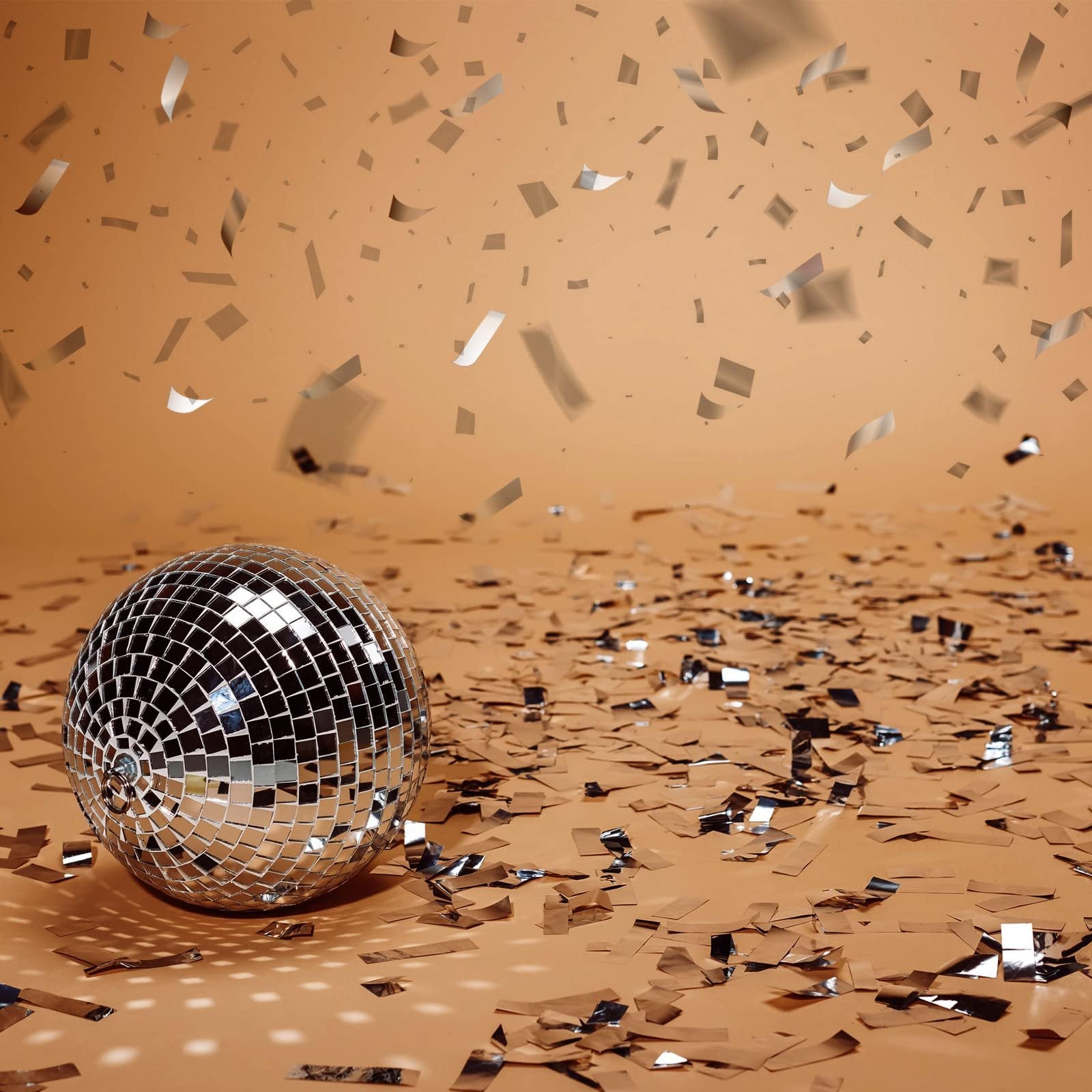 Disco ball surrounded by silver confetti on a peach background, with confetti falling from above.