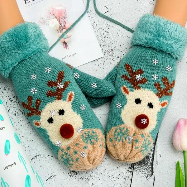 Pair of teal knitted mittens with reindeer and snowflake pattern, shown on hands.