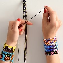 Hands weaving colorful friendship bracelets with embroidery floss and needles