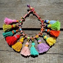 Colorful tassel necklace with beads on a wooden background