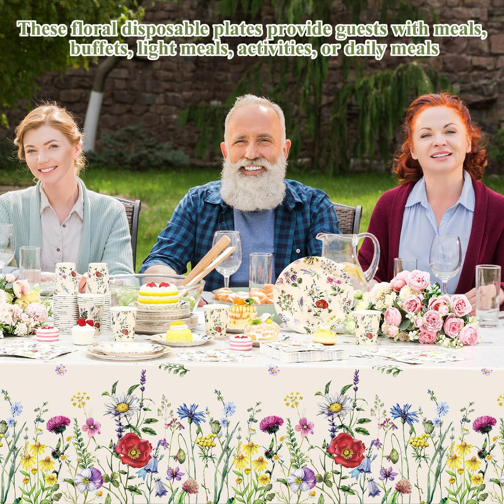 Three people enjoying a meal at a table set with floral disposable tableware outdoors