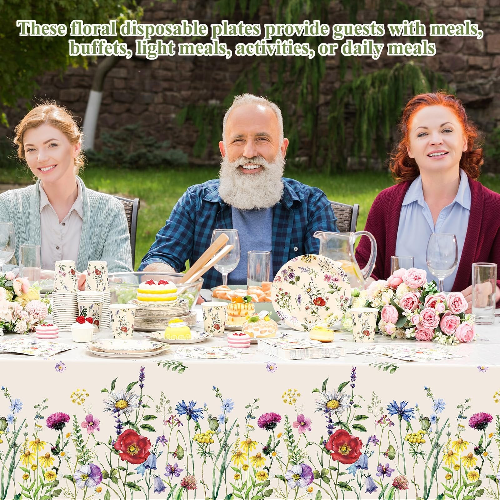 Three people enjoying a meal at a table set with floral disposable tableware outdoors