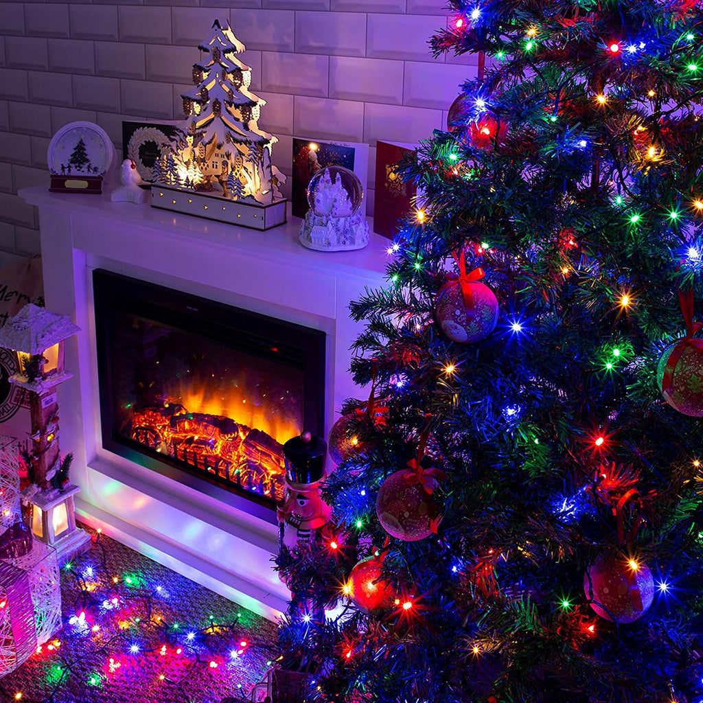 Multi-colored incandescent mini string lights on a Christmas tree and fireplace hearth