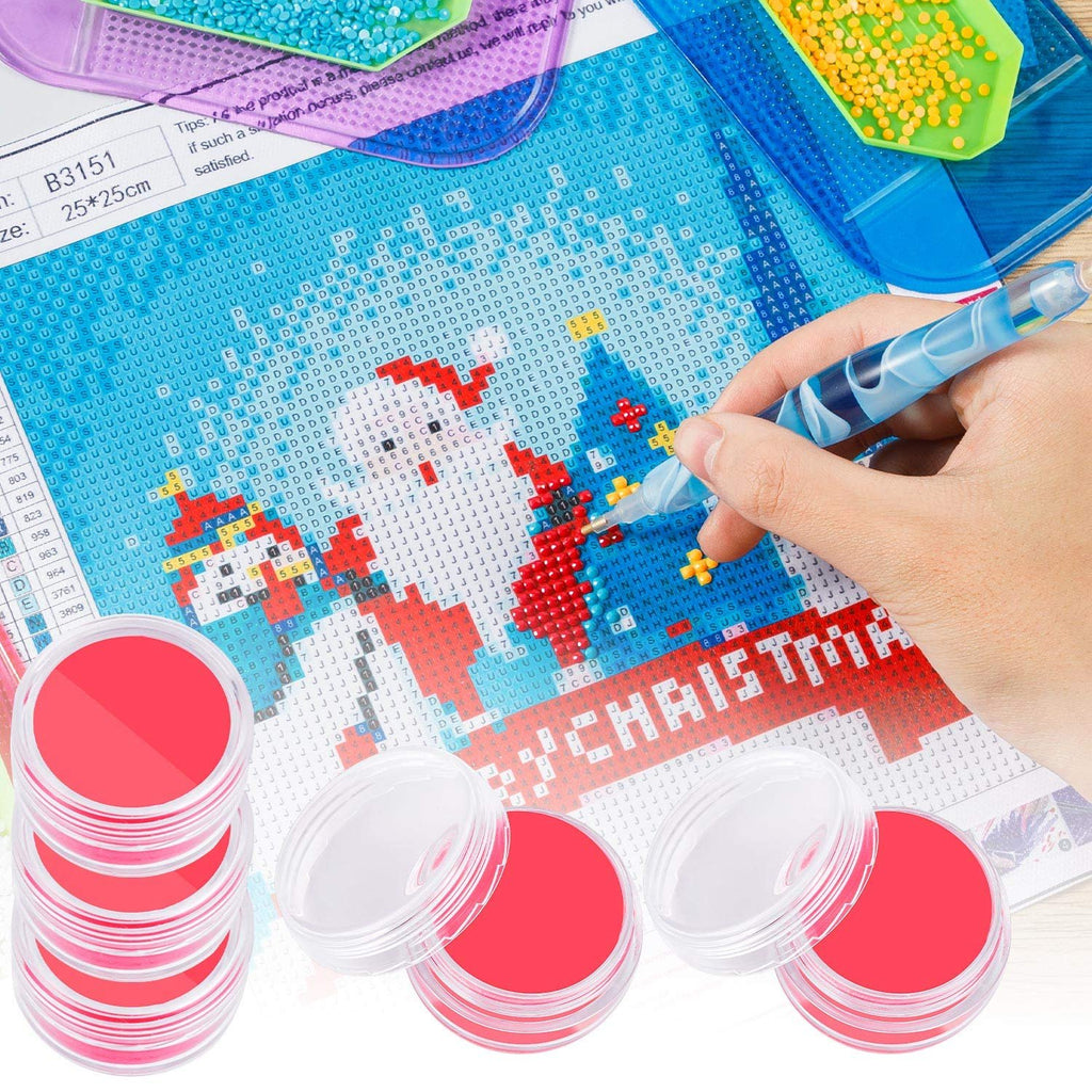 Diamond painting kit with red-lidded storage boxes and a diamond art pen, showing a partially completed Christmas scene.