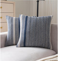 Two navy blue and white striped boho throw pillow covers on a sofa.